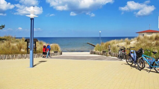 A paved walkway leading to the beach with a lamp post, a small shelter, and bicycles parked. - Sonnenblume by Interhome (Zempin)