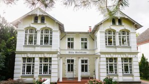 A two-story building with a symmetrical facade, large windows, and a central entrance. - Sonnenblume by Interhome (Zempin)
