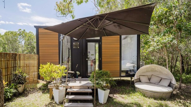 A modern outdoor living space with a covered patio, a seating area, and potted plants. - Clarence Farm Stay by Tiny Away (James Creek)