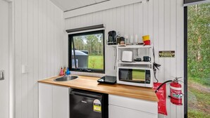 A compact kitchenette with a sink, microwave, and coffee maker. - Clarence Farm Stay by Tiny Away (James Creek)
