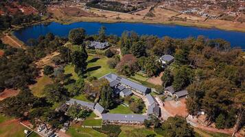 Vista aérea de una zona residencial con un lago grande, rodeada de casas y follaje.