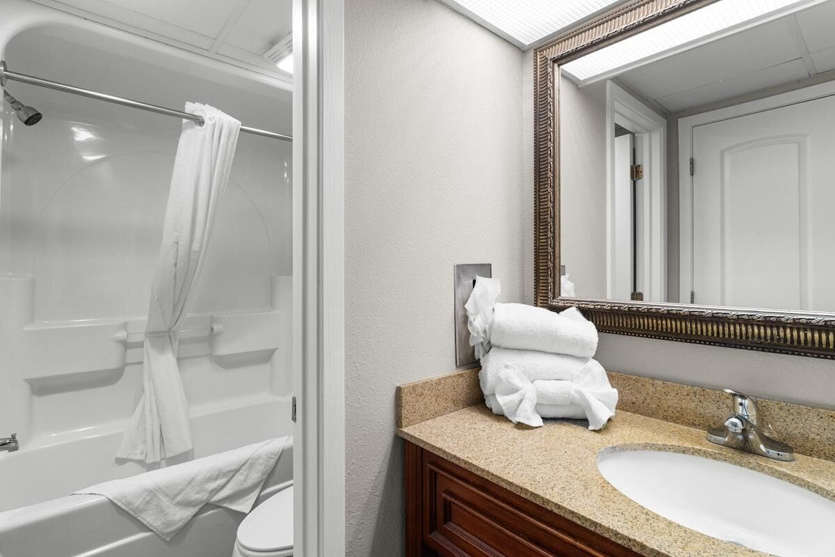 A bathroom with a bathtub, a sink, and a mirror.