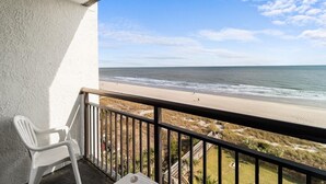 Un balcon avec vue sur la plage et l’océan.