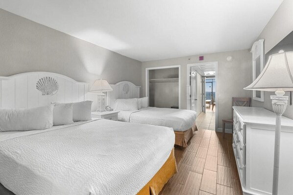 Een hotelkamer met twee bedden, een dressoir en een kaptafel met spiegel.