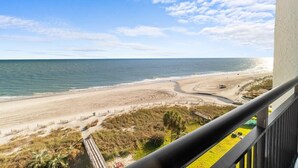 A beach view from a balcony with a railing, sandy beach, and ocean. - Beachy Oceanfront Suite with Breakfast 8th Floor (Myrtle Beach)
