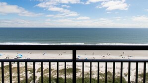 A beach view from a balcony with a railing, sandy beach, and ocean. - Astonishing Oceanfront Ste, 9th Flr, Breakfast (Myrtle Beach)