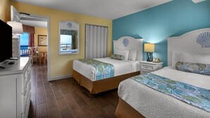 Une chambre d’hôtel avec deux lits, un bureau et une vue sur l’océan.