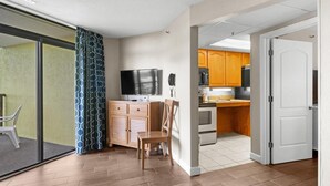 Eine moderne Wohnung mit Küche, Essbereich und einer Glasschiebetür, die auf einen Balkon führt.