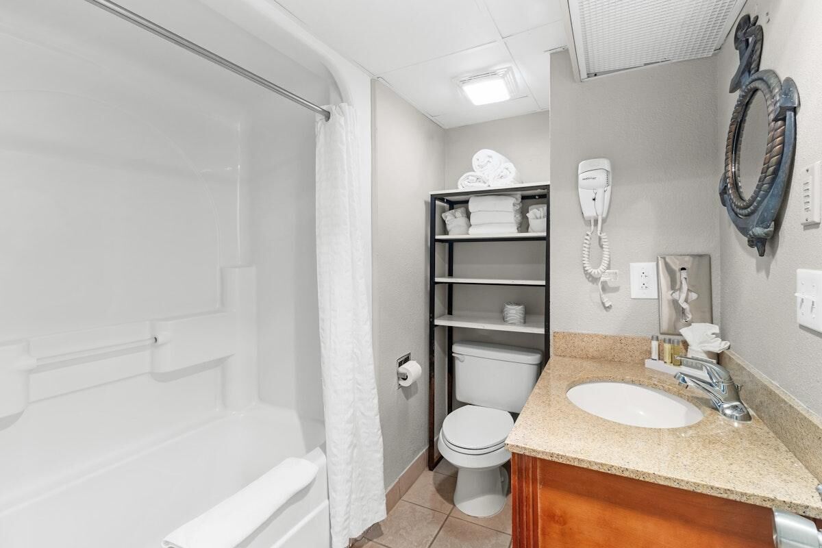A bathroom with a shower, toilet, and sink.
