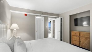 Ein Hotelzimmer mit einem Bett, einem an der Wand montierten Fernseher und einem Holzschrank.