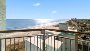 Ein Balkon mit Blick auf Strand und Gebäude.