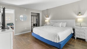Une chambre à coucher avec un grand lit, deux tables de chevet, une armoire et un miroir au mur.