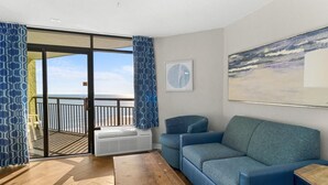 Un salon avec un canapé bleu, une table basse en bois et un grand tableau.