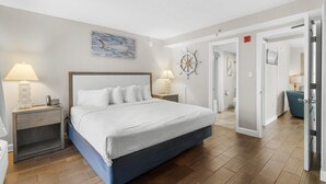A hotel room with a large bed, two bedside tables with lamps, a wall clock, and a nautical-themed artwork. - Mesmerizing Ocean View King Ste: Breakfast 14th Fl (Myrtle Beach)