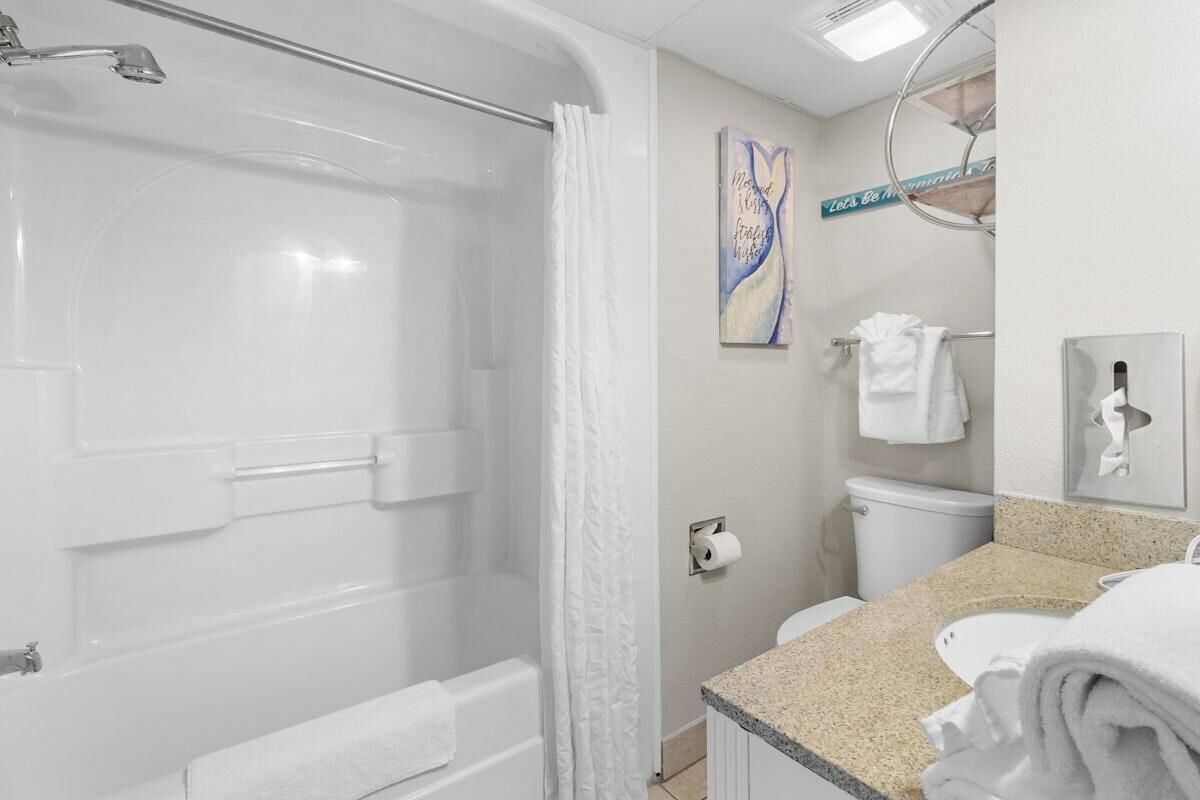 Een badkamer met een bad, toilet en wastafel.