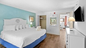 Ein Schlafzimmer mit Bett, Nachttisch, Lampe, Fernseher und Kleiderschrank.