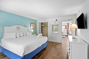 A bedroom with a bed, a bedside table, a lamp, a TV, and a wardrobe. - Inspiring Ocean View Ste with Breakfast 11th Flr (Myrtle Beach)