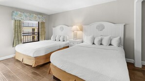 A hotel room with two beds, a nightstand with a lamp, and a view of a balcony. - Inspiring Ocean View Ste Free Breakfast 12th Flr (Myrtle Beach)
