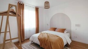 A bedroom with a bed, a wooden ladder, a hanging light fixture, and a window with curtains. - Maison 6pers 1,2km de la Plage Smarttv Fibre (Les Sables-d'Olonne)