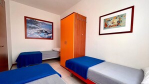 A room with two single beds, a wooden wardrobe, and two framed pictures on the walls. - Luminous Flat With Balcony (Caorle)