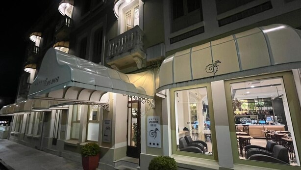 Un hotel con fachada moderna, amplias ventanas y una entrada bien iluminada.