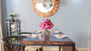 A dining area with a wooden table, black metal chairs, and a central mirror. - Stylish, light villa w/pool. All modern amenities, gated. Right by the beach. (Rodney Bay)