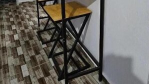 Un pasillo con piso de madera y una mesa con estructura de metal negro.