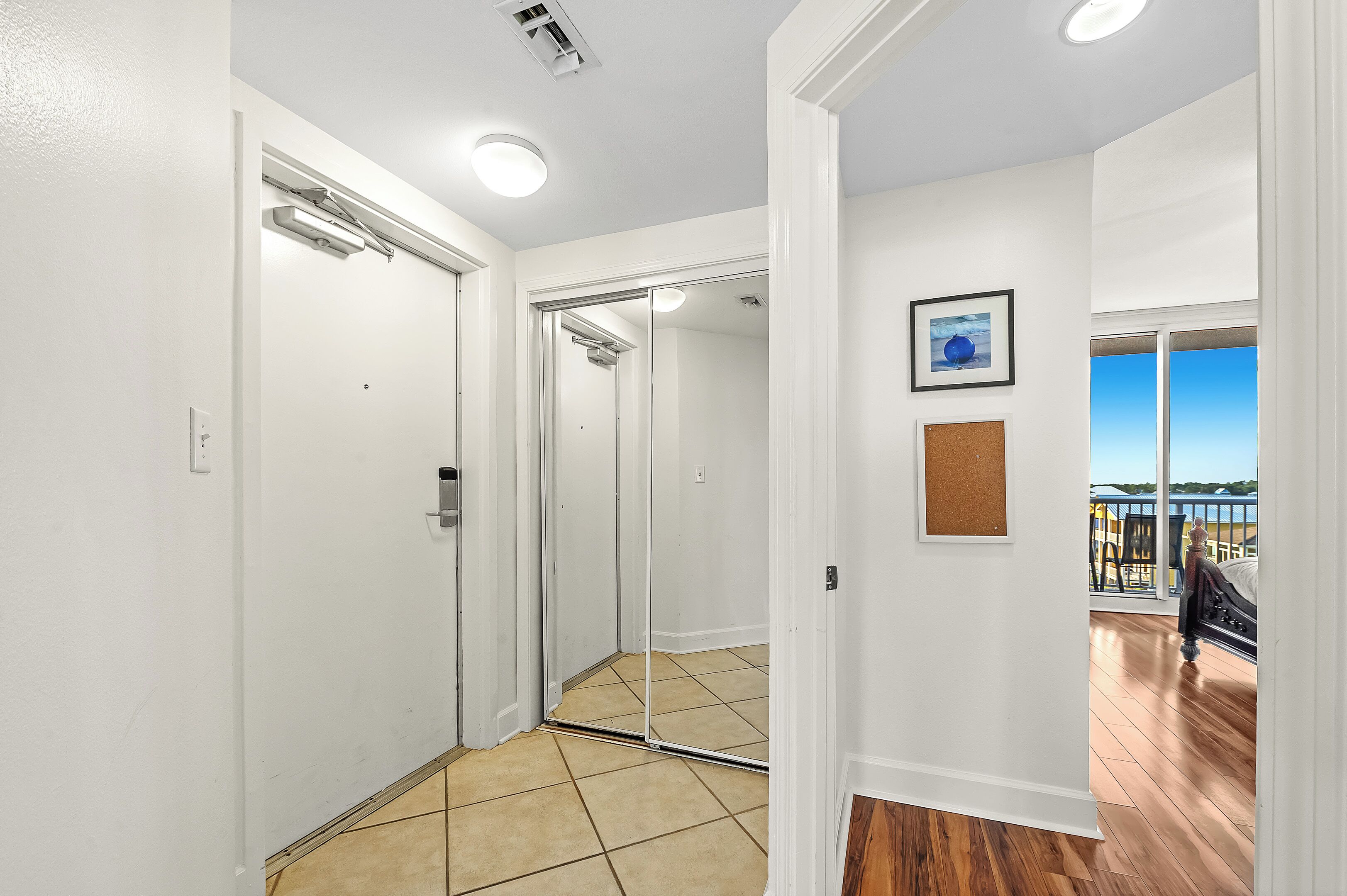 A hallway with a sliding door leading to a balcony with a view.