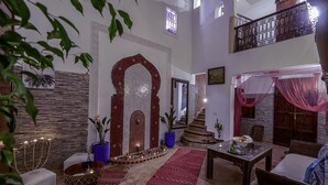 Uma sala de estar ampla com teto alto, escada e varanda.