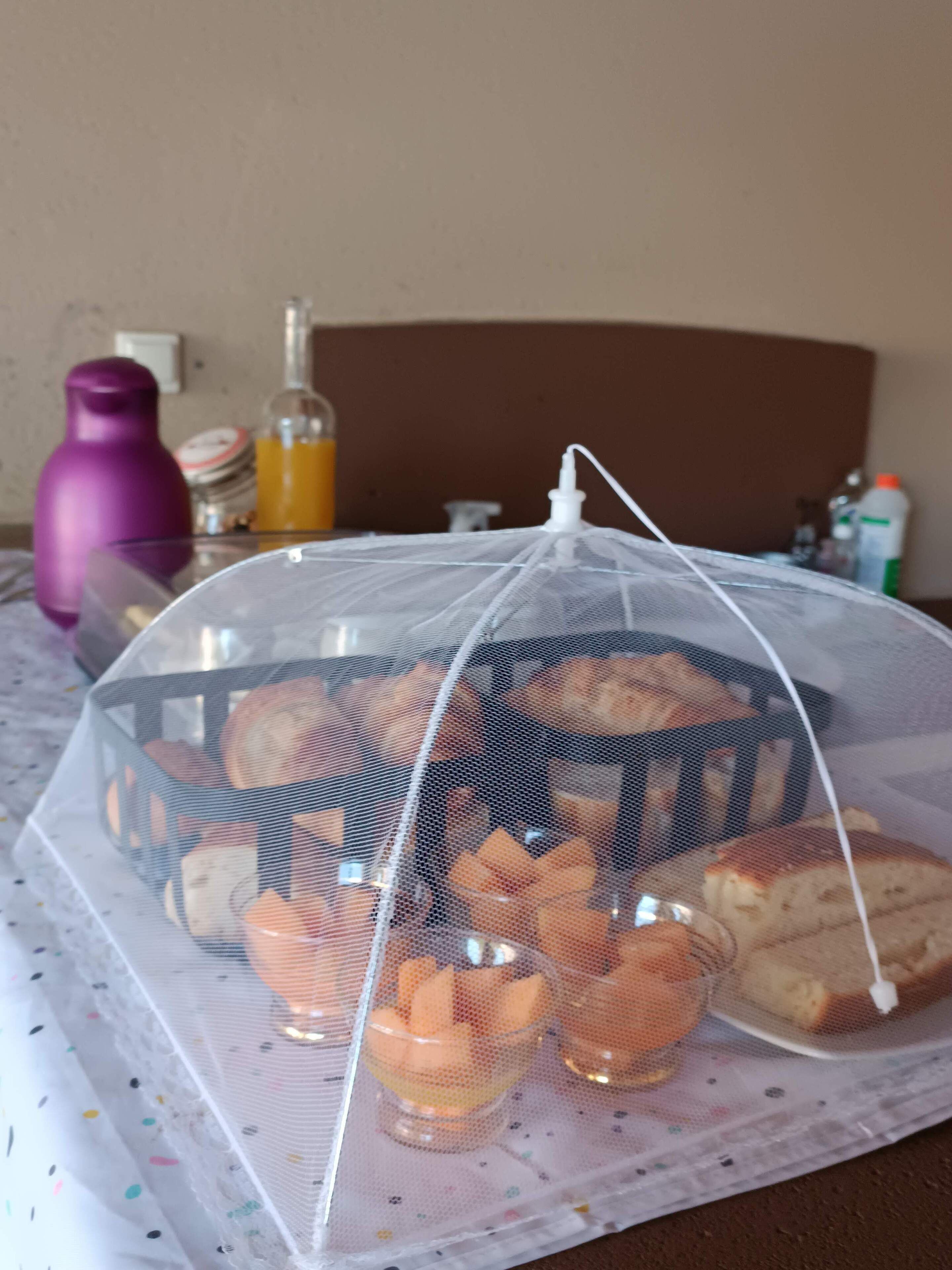 Exposição de comida coberta com diversos produtos de panificação e bebidas sobre uma mesa.