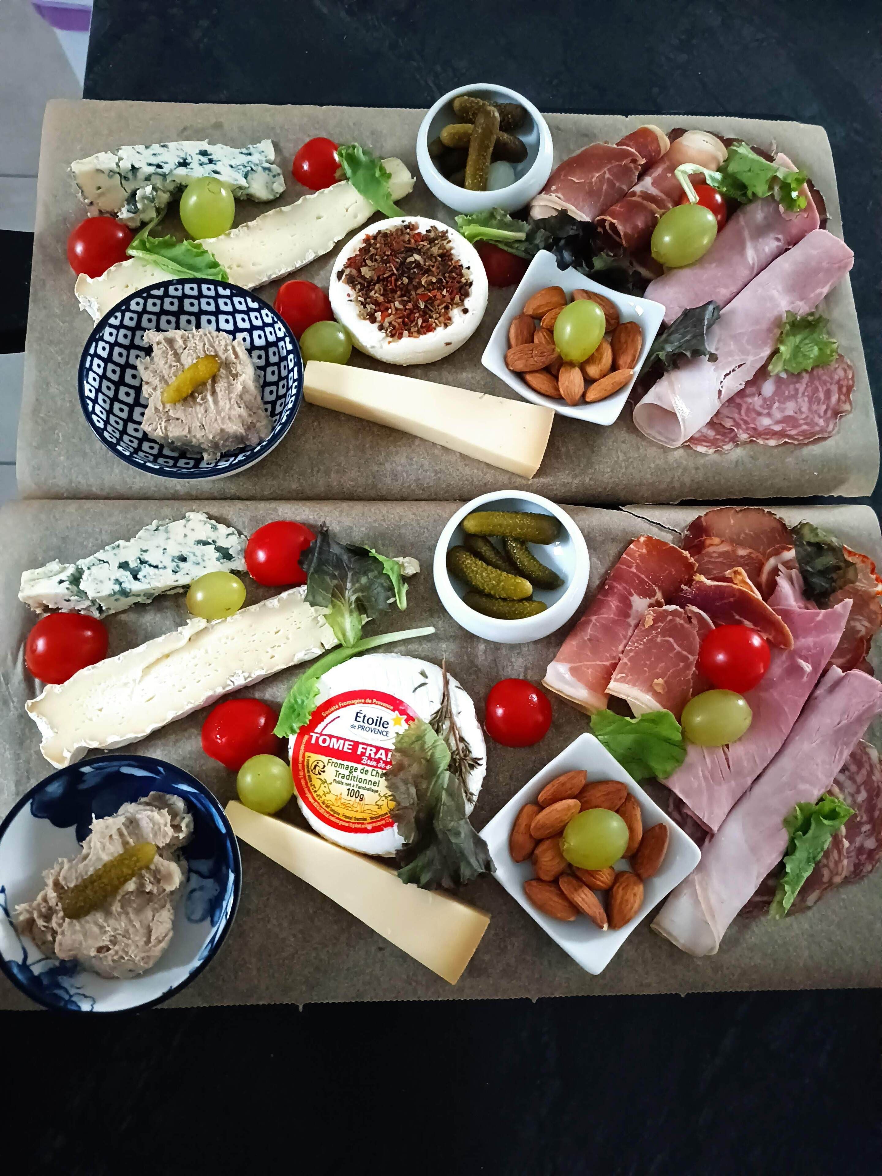 A charcuterie board with various cheeses, meats, fruits, and nuts.