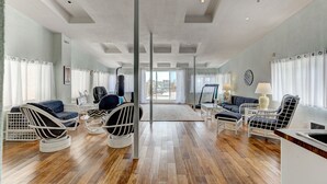A spacious living area with a wooden floor, white furniture, and large windows with curtains. - Cozy 2 bedroom Condo at the Château Sherbrooke, Blend of history & modern luxury (Montréal)