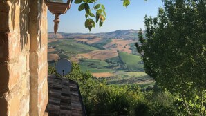 A stone building with a lantern and a satellite dish, overlooking a vineyard and rolling hills. - Ephemeral - Relaxing Retreat (Abruzzo)