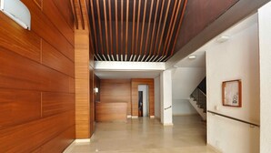 A spacious hallway with wooden paneling on one side and a white wall on the other, leading to a staircase. - Spacious apartment 8 people, sea view terrace, Lloret de Mar (Lloret de Mar)