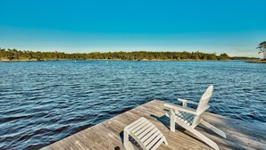 A wooden dock extending into a calm lake with a clear blue sky.