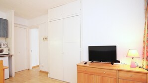 Ett rum med ett träskåp, en tv, en lampa och en mikrovågsugn.