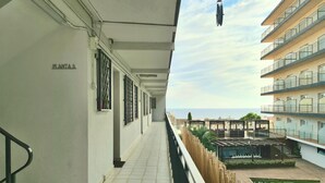 Un pasillo con un letrero que dice "PLANTA 5", que conduce a una terraza con piscina y vistas al mar.