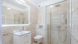 A modern bathroom with a glass-enclosed shower, a white sink, and a toilet. - Comfortable Studio | Parking, Balcony, Close to the Beach (Miedzyzdroje)