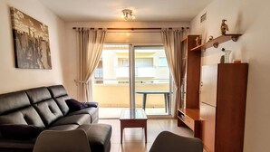 Ein modernes Wohnzimmer mit einer Ledersofa, einem Glastisch mit gewebten Untersetzern, einem Holzschrank und einem Stadtbild an der Wand.