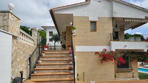 A two-story house with a stone facade, a tiled staircase, and a pool area. - Modern villa 1 km from beach with private pool and sea views (Lloret de Mar)