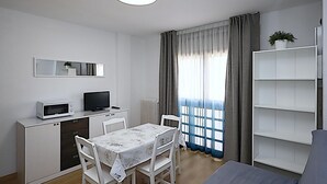 Ein kompakter Wohnbereich mit Küchenzeile, einem Essbereich und einer Sitzecke mit Sofa.