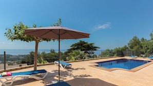 Ein Poolbereich auf dem Dach mit zwei Pools, Liegestühlen und einem Sonnenschirm.