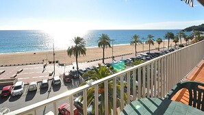 A balcony with a view of a beach, parked cars, and palm trees. - 2-BR Apartment, 4-6 people, Lloret de Mar center, WiFi, close to beach (Lloret de Mar)