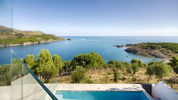 Une piscine offrant une vue dégagée sur la mer et le paysage environnant.