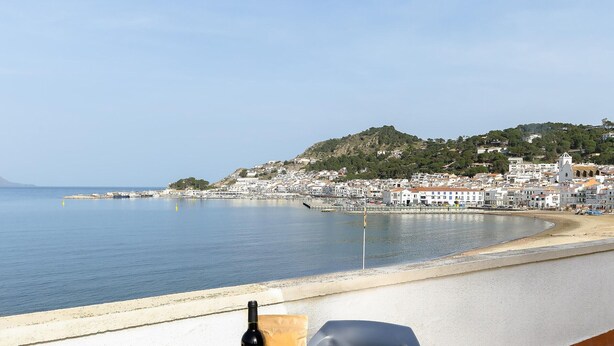 A coastal view with a table featuring a bottle of wine and a bag of snacks. - Seafront Penthouse for 6 with Terrace and Shared Pool (El Port de la Selva)