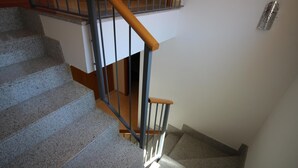 A staircase with granite steps and a wooden handrail.