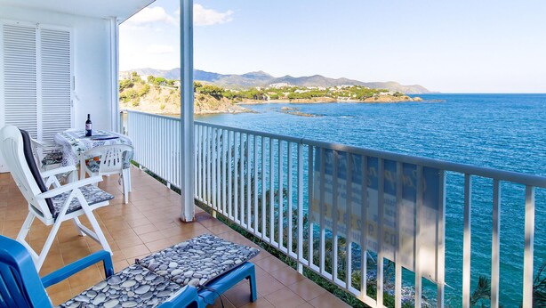 A balcony with a view of the sea, a table with a bottle, and a chair. - Apartment with Terrace 300m from Beach, Parking Included (Llançà)