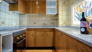 Una cocina con armarios de madera, encimera de granito y salpicadero de azulejos.