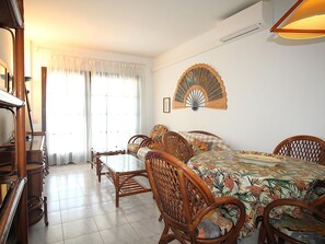 A dining area with a table, chairs, and a fan on the wall.