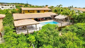 A residential property with a swimming pool, covered patio, and lush greenery. - Villa Kromboon with a private pool, spectacular views and jacuzzi (Kralendijk)